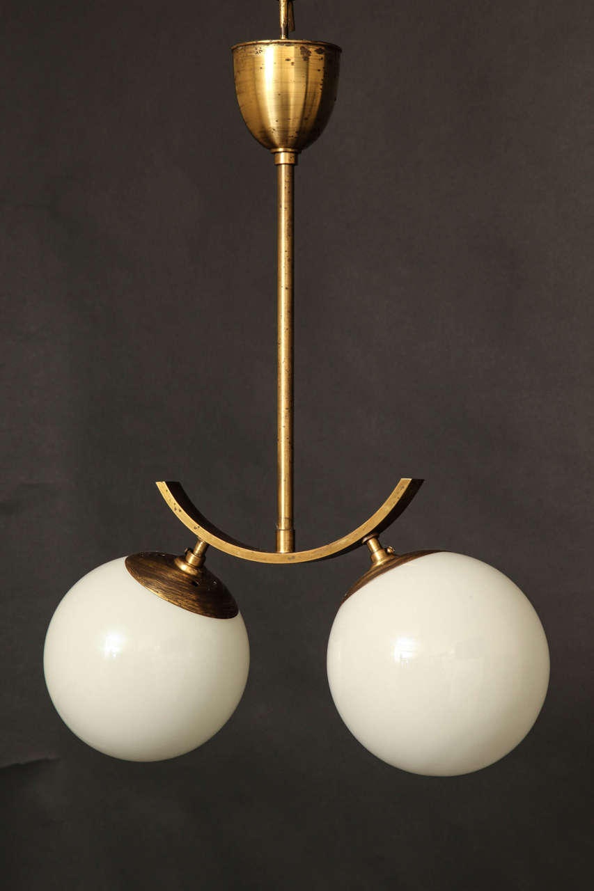 A Whimsical Brass Pendant With Two Opaline Glass Spheres.