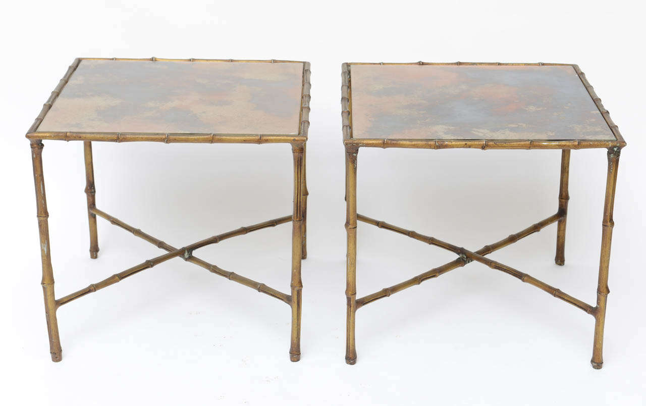 Gilded aluminum side tables with reverse painted glass tops.