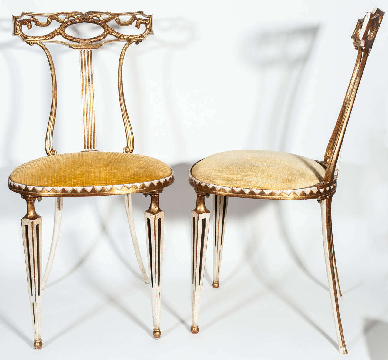 Elegant set of four chairs by Palladio. Cast iron, ivory tone frame with gilded decorative motives and upholstered seats.