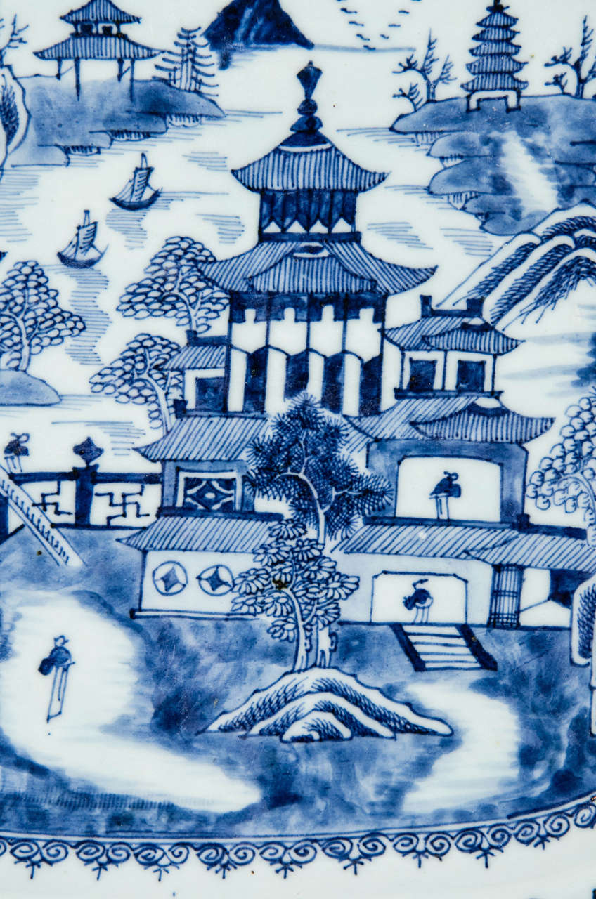 An 18th century Chinese Blue and White platter decorated with pagodas and a waterside scene. The form is a traditional cut corner rectangle.
