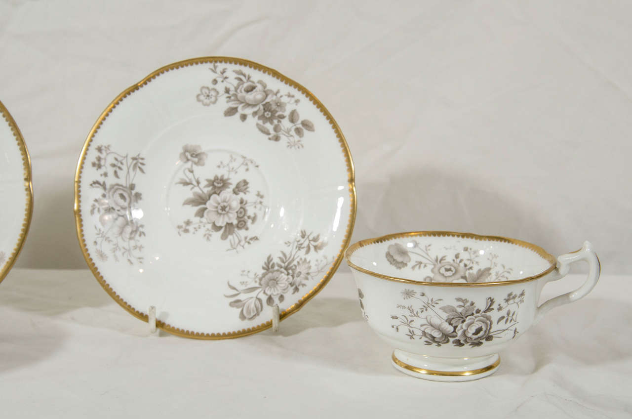 The cups are decorated inside and outside with bouquets of spring flowers painted in grisaille. Each cup and saucer with a beautifully gilded border.
