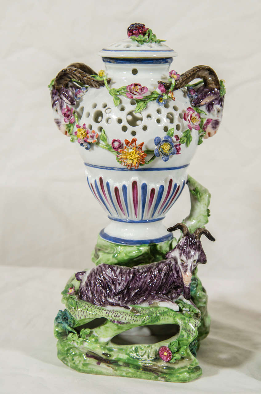 A pair of French 19th century potpourri vases each with a ram or ewe resting on a bed of grass. The upper portion of each pierced vase is decorated with applied flowers. The handles are in the form of a ram's head.