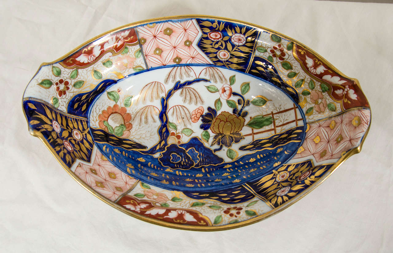 This popular early 19th century Spode pattern shows a hand-painted scene with a fenced garden, blue rocks, peonies and a willow tree with golden branches. The pattern is now known by several names; 