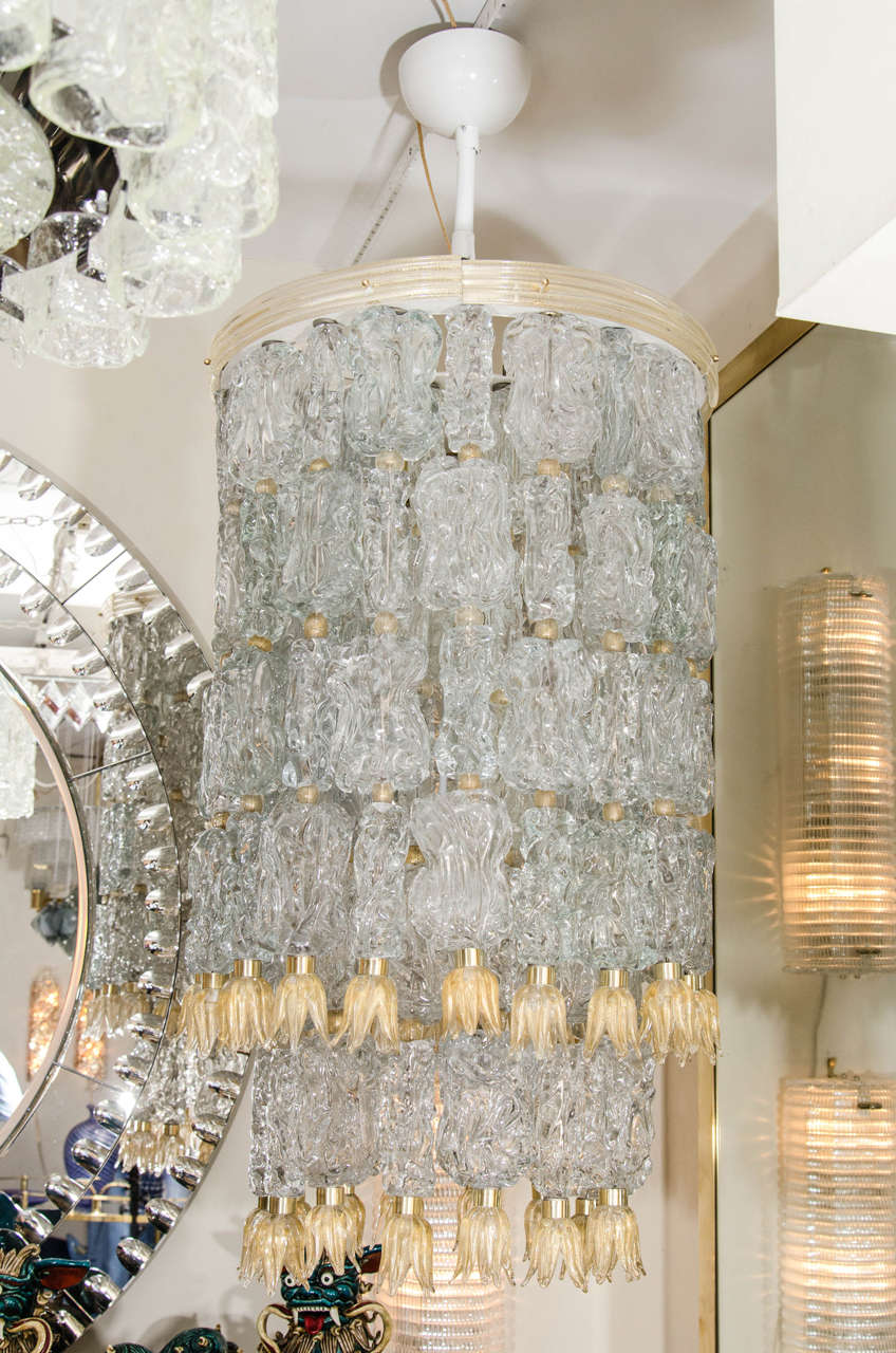 Tiered chandelier composed of textured clear glass elements with golden glass tulip form details