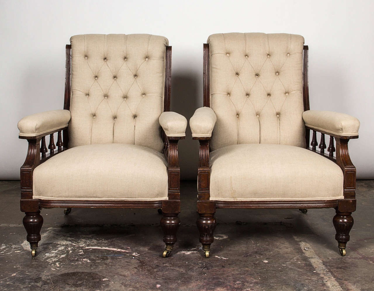 Rectangular button-tufted backrest with exposed frame sides over the rectangular seat flanked by padded and turned spindle arms. Covered in white linen fabric over turned legs and casters. Possibly late 19th century American.

Not available for