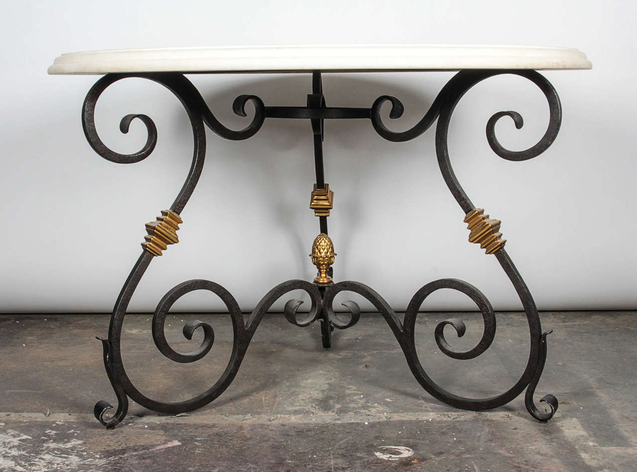Elegant scrolls of oxidized iron form the base to this Art Nouveau-inspired table. Scrolling iron is accented by gilt brass knuckles and completed with a round limestone surface.

Not available for sale or to ship in the state of California.