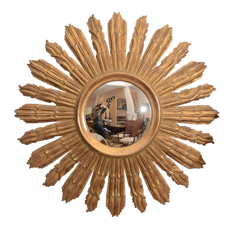 A small single ray giltwood mirror with a highly decorative giltwood band surrounding the mirror (9 1/2