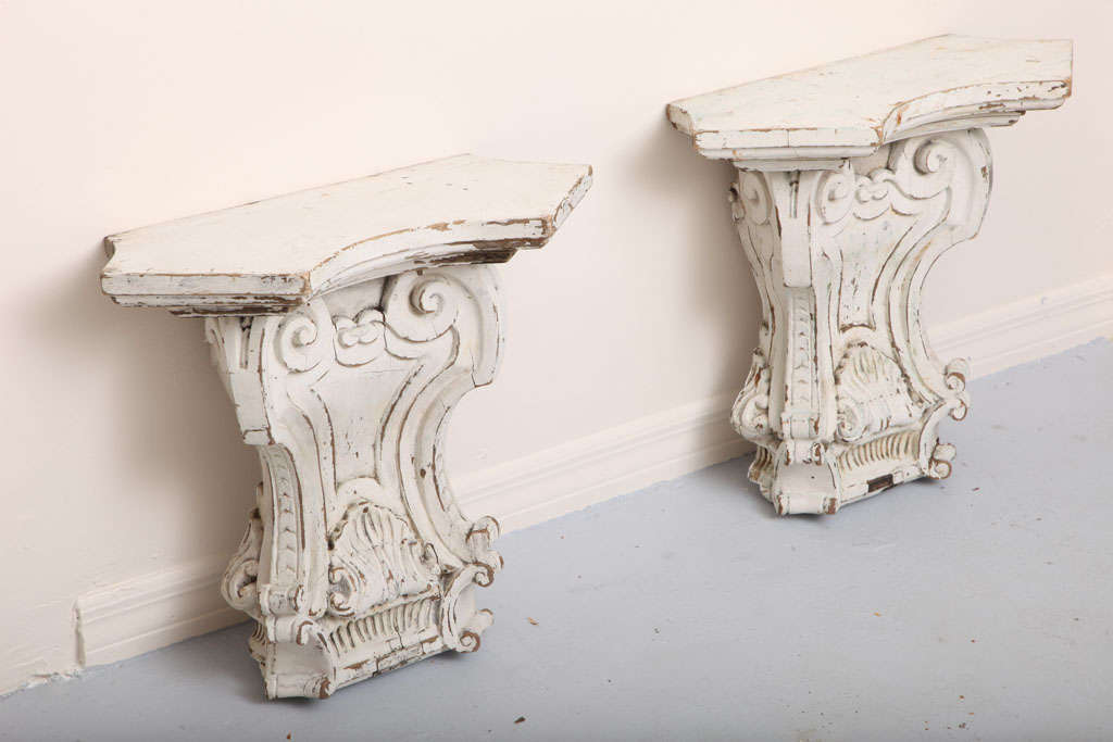 Substantial pair of carved wood wall brackets with original paint and great patina with shell motif.
