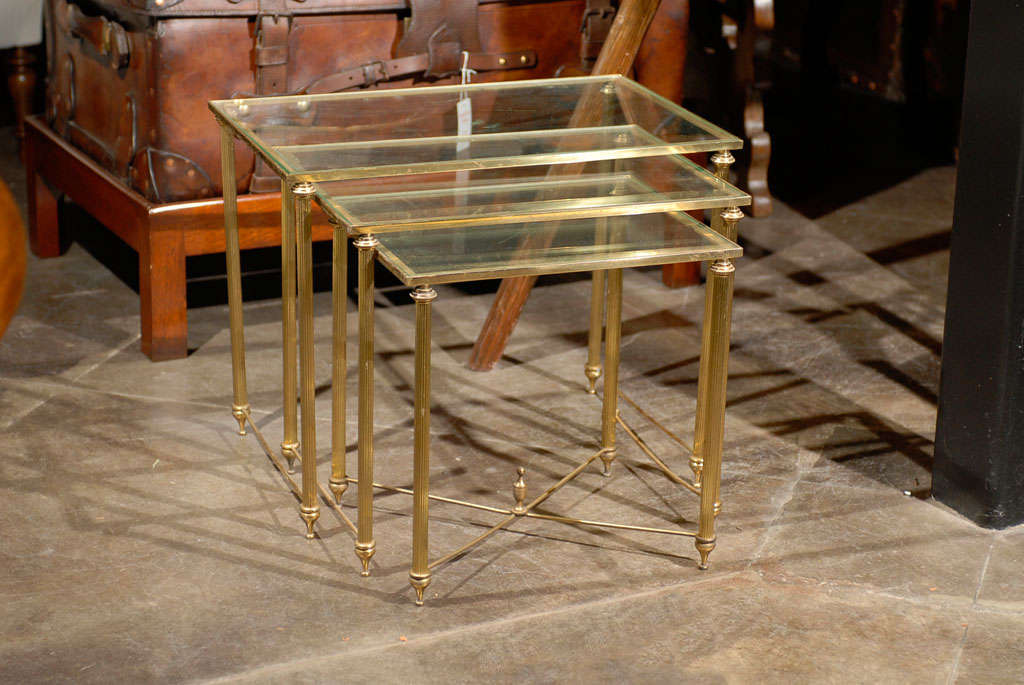 Nest of 3 Brass tables with glass tops.