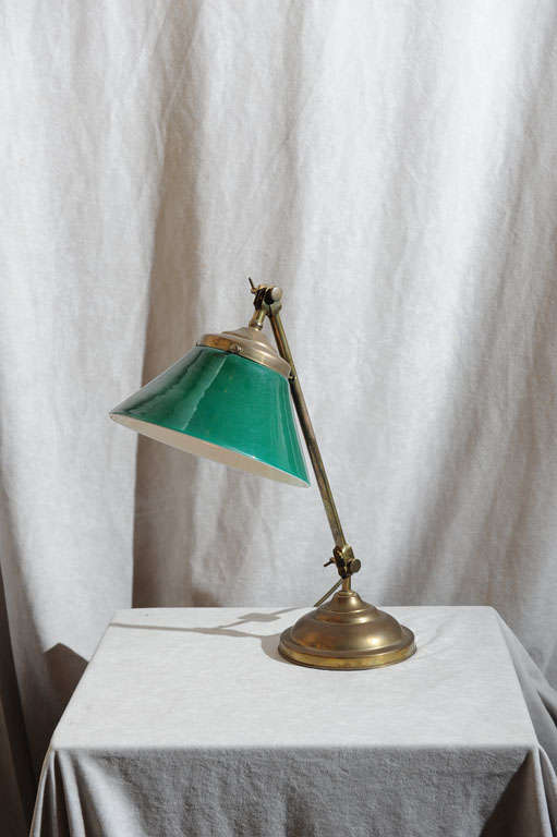This super clean, signed brass desk lamp by the noted company Faries has a double knuckle for height and angle adjustment of shade.  The beautiful original green cased glass shade keeps the light bulb from being seen.  The exterior of the glass is