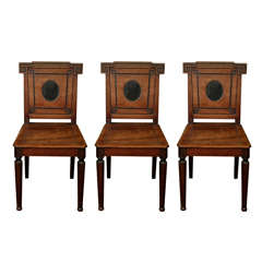An exceptional set of three Grecian revival hall chairs  