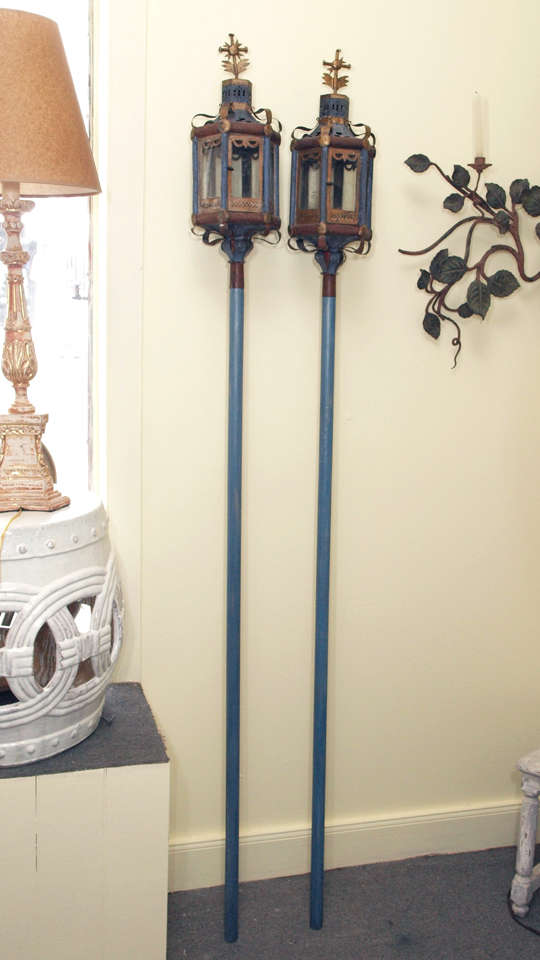 Pair of 19C Italian painted and gilt tole hexagonal form ceremonial lanterns.  The rectangular glass paneled sides have frames embellished with fenestrations at the lower aspect and a swag at the upper. One of the panels is hinged and has a knob. 