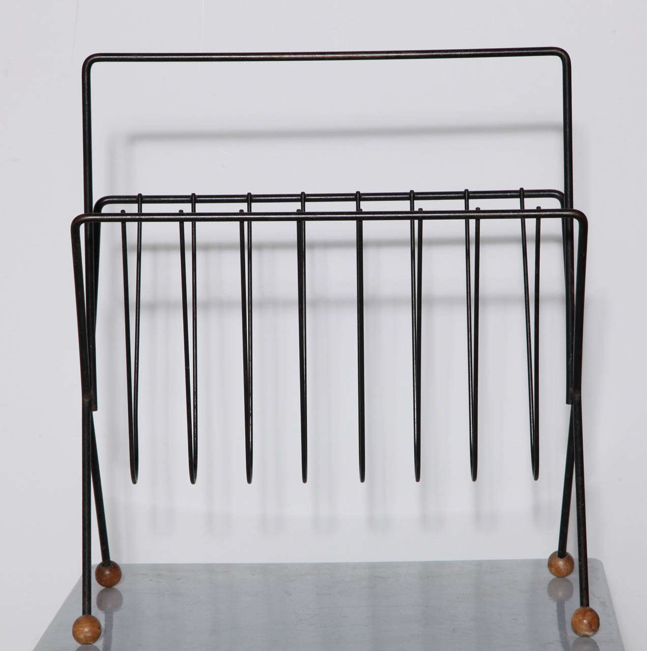Mid Century Black Iron Atomic Magazine Rack attributed to Tony Paul - 
with handle and round wooden feet
