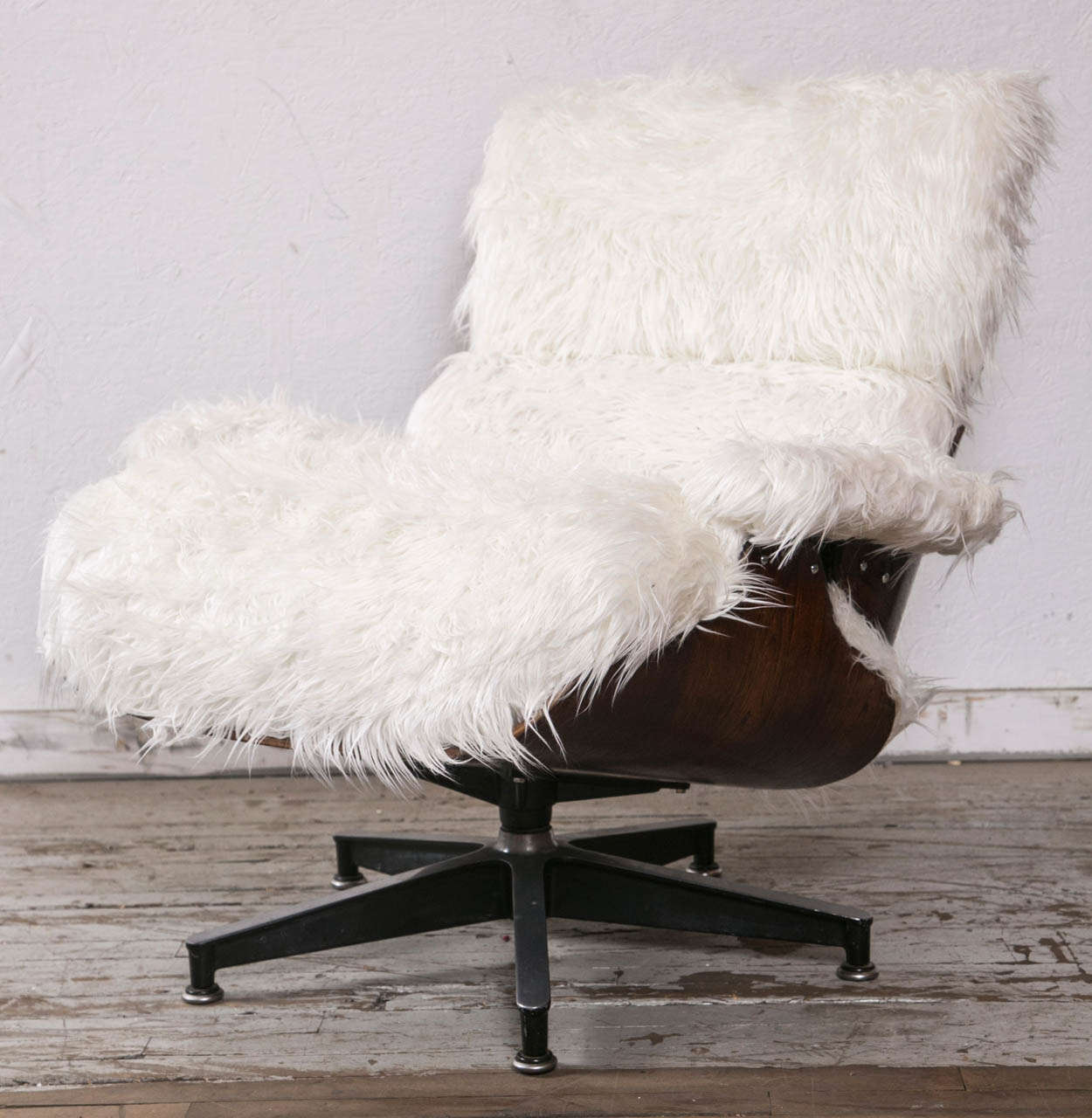 The iconic  Charles and Ray Eames 670 Rosewood lounge chair was
manufactured by Herman Miller Manufacturing Company in Zeeland, 
Michigan during the 1960's. It has been refinished and reupholstered in faux Mongolian Fur. The white color is a great