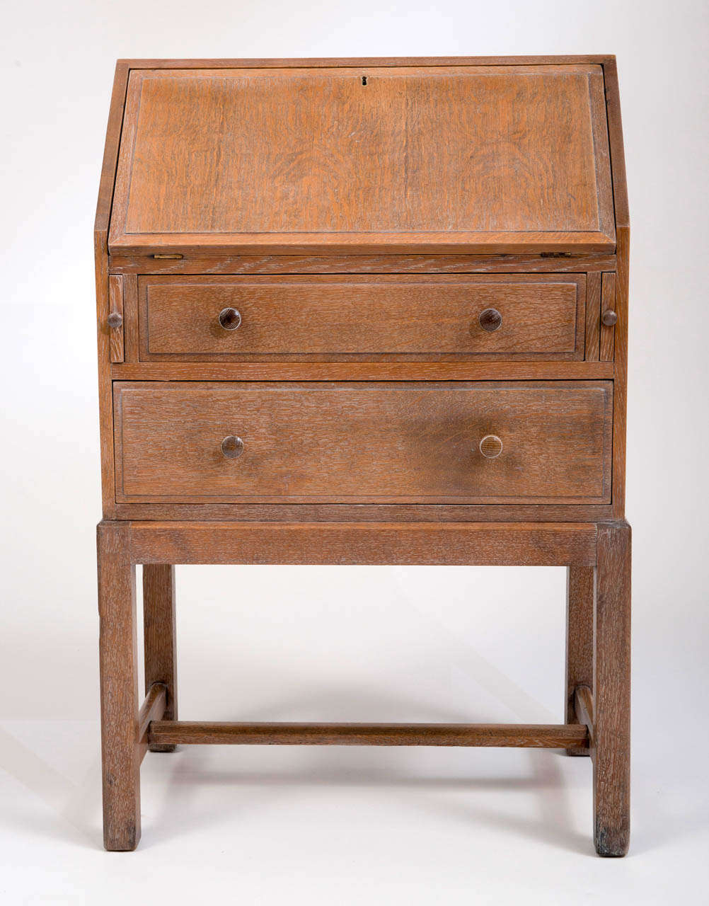 Heals and Son limed Oak fold down bureau
The fall front opening to reveal pigeon holes.
Two graduated drawers.
Four square legs united by a “H” stretcher.
Ivorine disk to drawer with makers mark.
English
Circa 1930
94 cms hx 61cms w x 38cms d
