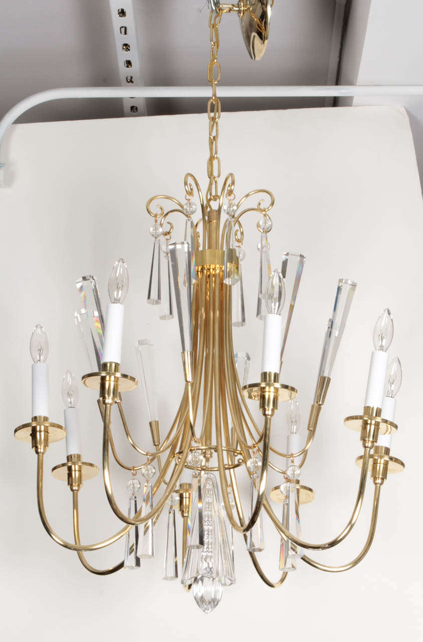 Fantastic brass eight-arm chandelier with faceted elongated crystal drops and spikes. Stamped made in Germany, distributed thru Lightolier, chandelier has eight lights, and 1 ft. of brass chain... With chain, height is 37.5 inches.