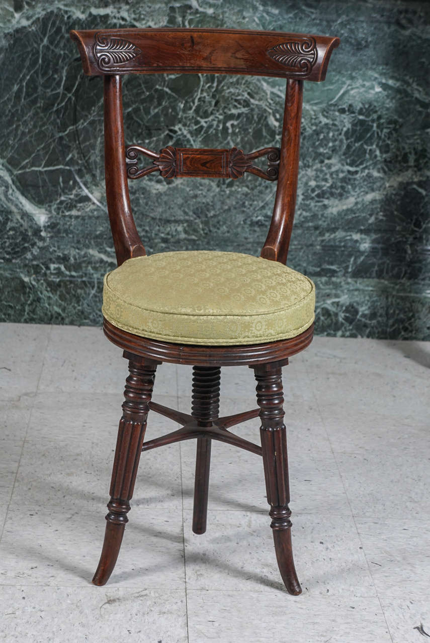 This good piano stool made in England circa 1840 of imported rosewood was at its time the height of fashion. Crafted in a modified classical style  the back rest is centered with an rectangular panel  flanked by anthenium while the crest rail
