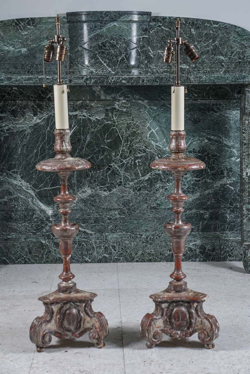 This pair of candlesticks made in the Netherlands of carved and turned wood that has been gessoed and silver gilded are from about 1740. The large scale and dramatic profile make then desirable and impressive. Now made into electrified lamps they