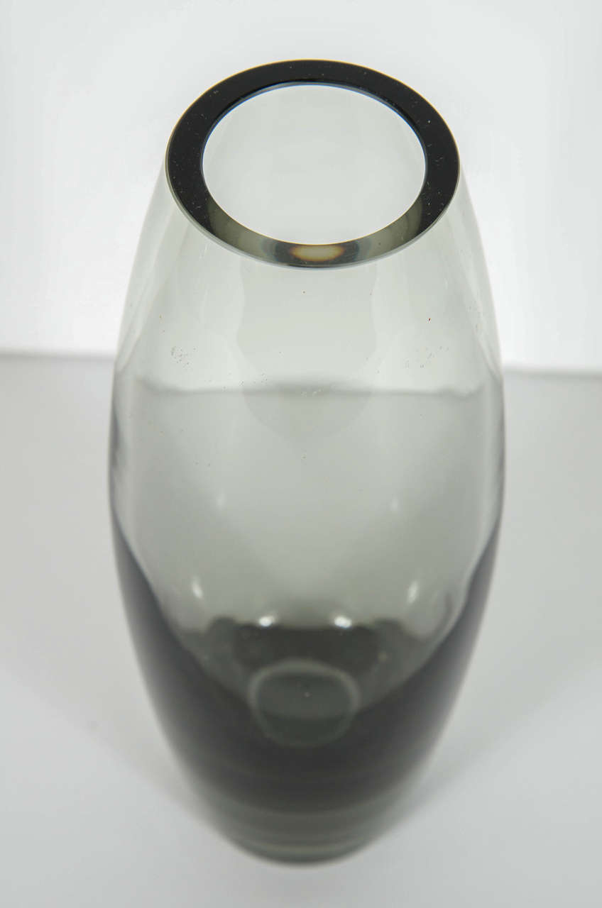 Mid-Century Modernist handblown smoked glass vase by Holmegaard. This ultra chic glass vase by Holmegaard is of handblown smoked glass that Holmegaard is known for and accented with an ombre effect ranging from the smoked glass base to its lighter