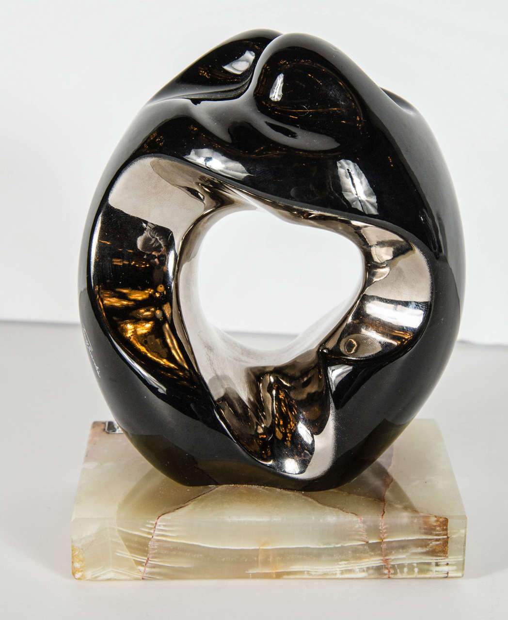 Mid-Century Modernist bronze ceramic sculpture by Torres Gaurdia.  This sculpture by the famous artist Torres Guardia, from Spain, features a couple embracing and cast in bronzed ceramic then set atop an exotic Onyx base.  The interior of the