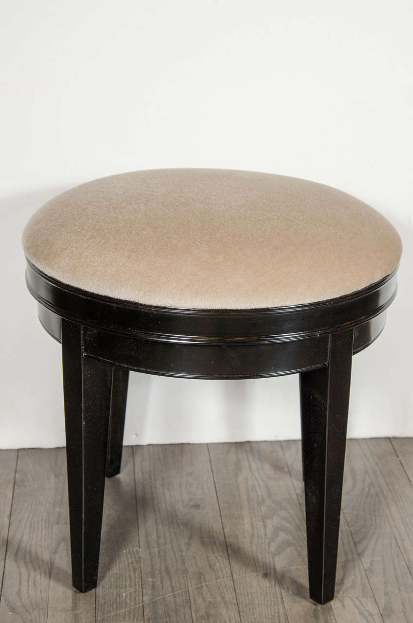 This sophisticated circular Art Deco swivel vanity stool is newly upholstered in camel mohair with tapered legs in ebonized walnut. Restored to mint condition.