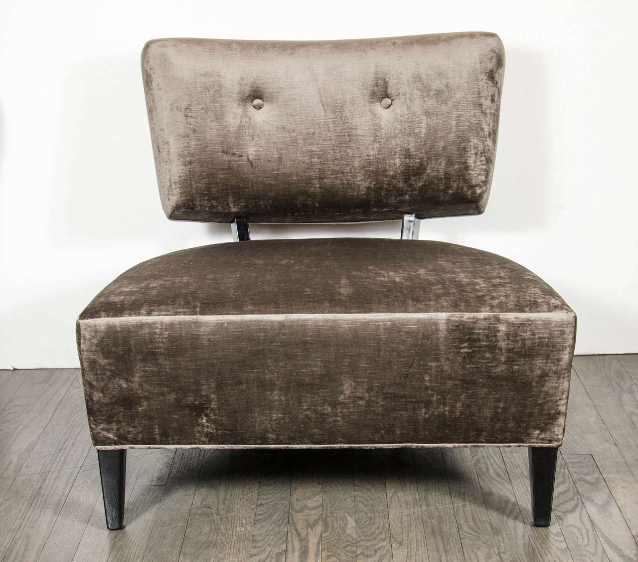 This superb pair of Mid-Century modernist Klismos style slipper chairs feature a low profile with modern lines with a wide generous seat and open back with button detailing. They have been newly upholstered in a smoked pewter velvet and have