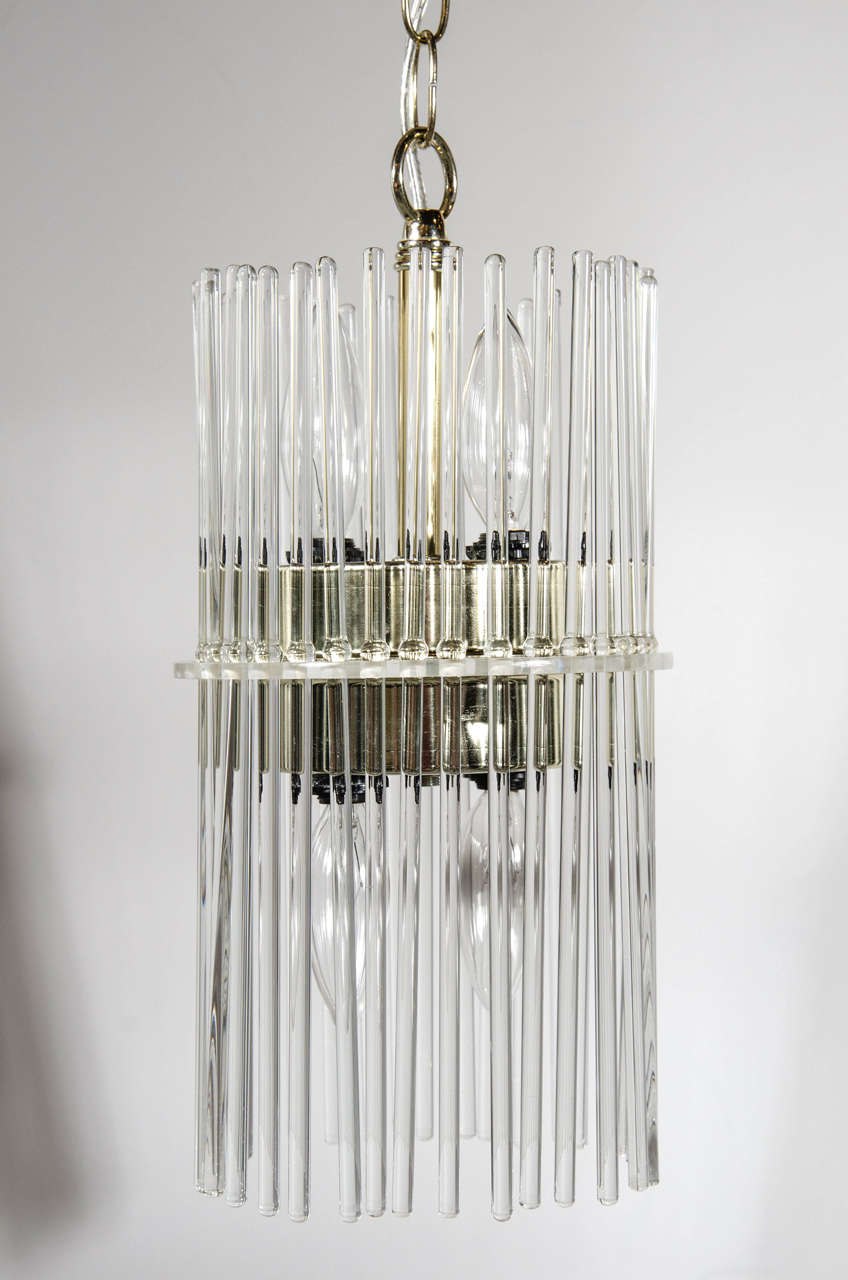 Pair of Mid-Century Modernist glass rod pendant chandeliers by Gaetano Sciolari for Lightolier. This pair of pendant chandeliers feature numerous glass rods that independently suspend from their lucite disc that is supported by the pendants interior