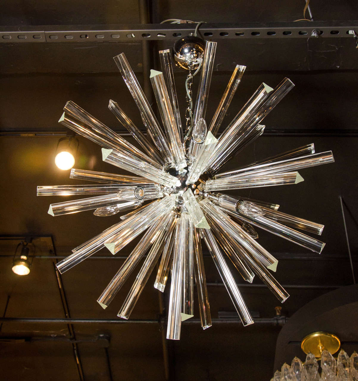 This striking Mid-Century Modernist chandelier features a Sputnik design, numerous Murano glass triedre shaped rods emanating from a chrome spherical centre, and has nine bulbs (providing up to 75 watts per bulb). It has been newly rewired to