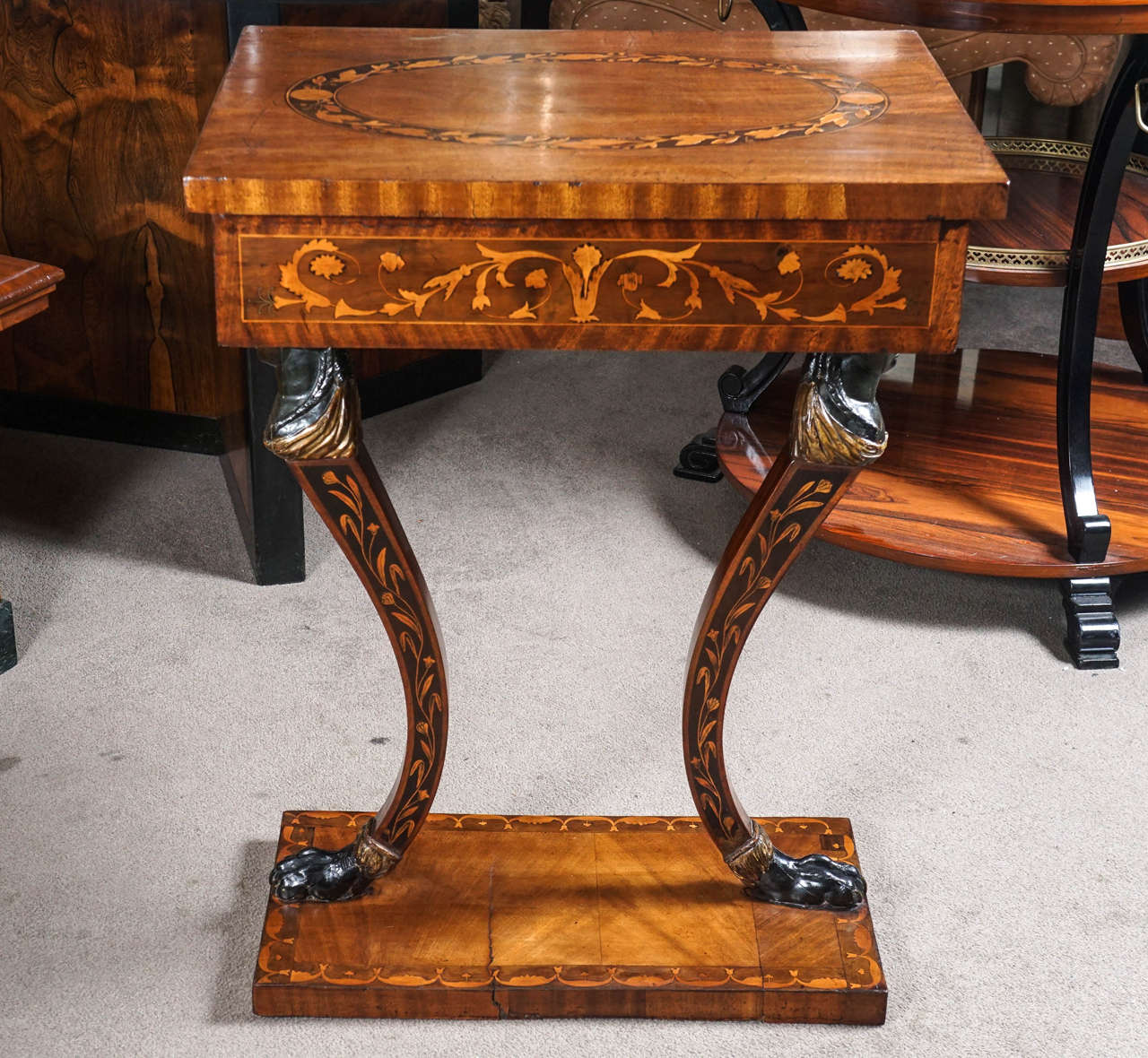 Italian NEOCLASSICAL WALNUT AND FRUITWOOD MARQUETRY SIDE TABLE 
The overhanging rectangular top with a foliate oval reserve above the frieze similarly inlaid, raised on female monopodia on an inlaid rectangular plinth base. 30 x 23 x 18 in.