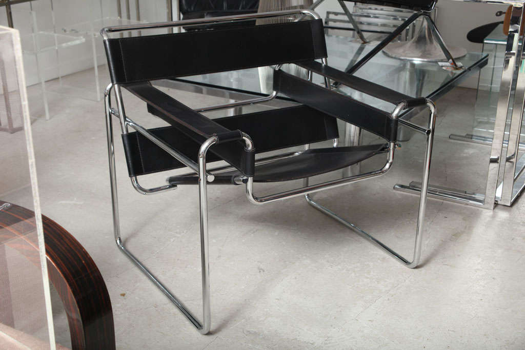 TUBULAR METAL IN CHROME WITH BLACK LEATHER STRAPPING FOR ARMS, SEAT AND BACK.CHAIR IS SIGNED WITH LABEL.