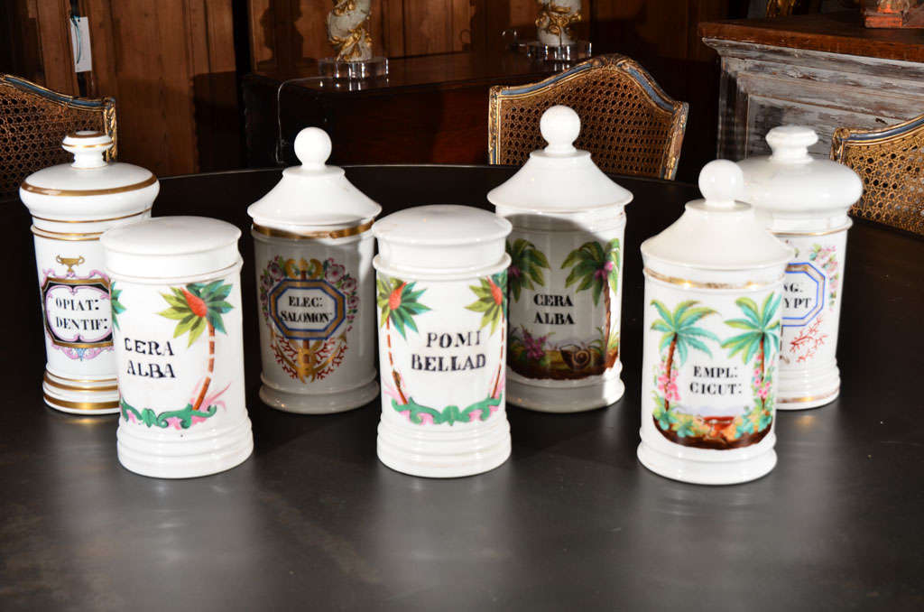 Porcelain apothecary jars, with hand painted Latin labels, from 19th century, France. Flat lids cover two jars and lids with handles cover five jars in this set. Jars sold separately priced $650 each.