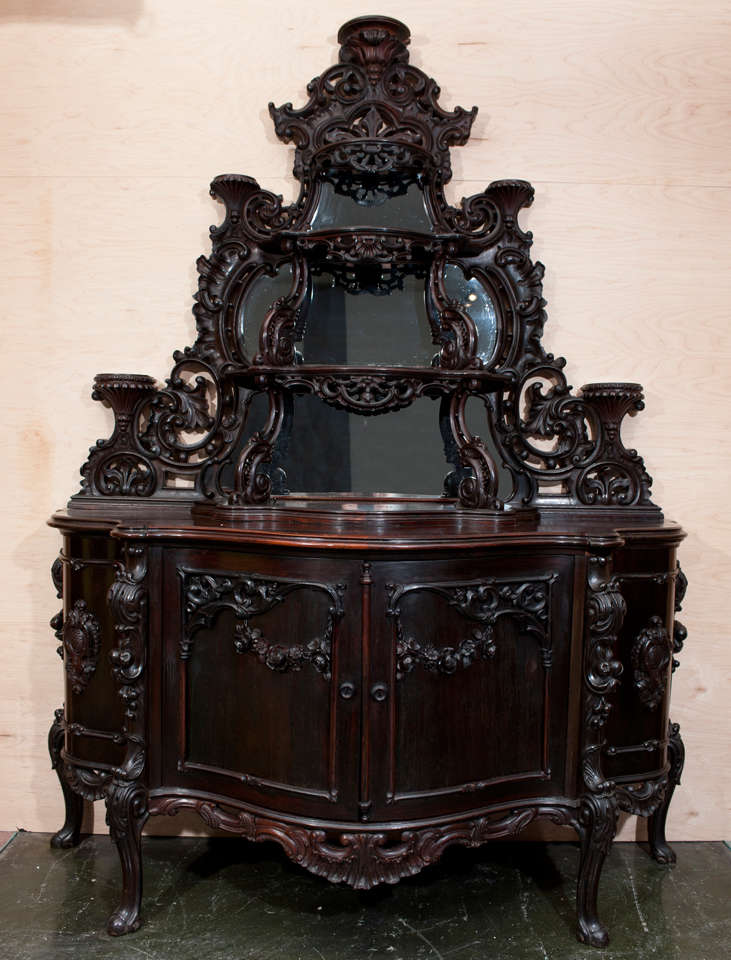 Impressive Victorian Rococo etagere. Elaborately carved cabinet base in a fruit and floral pattern with a scrolled carved mirrored top.