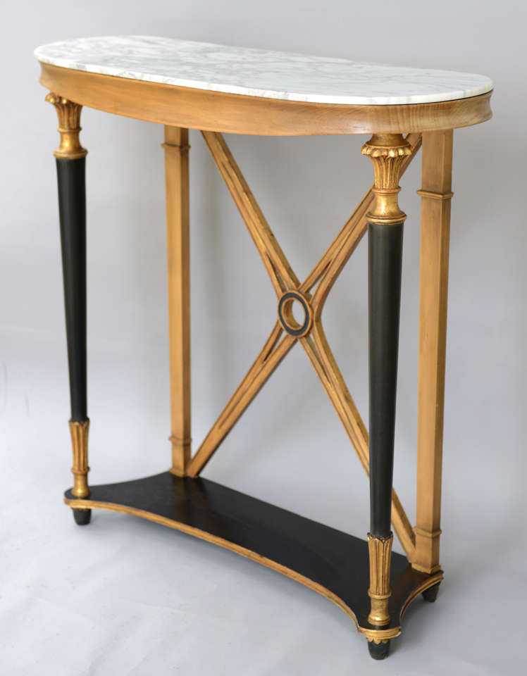 Console, having an ovoid top of white marble with gray veining, on conforming table base with painted and parcel gilt finish, shaped apron raised on tapering columnar legs with pierced X-rear stretcher