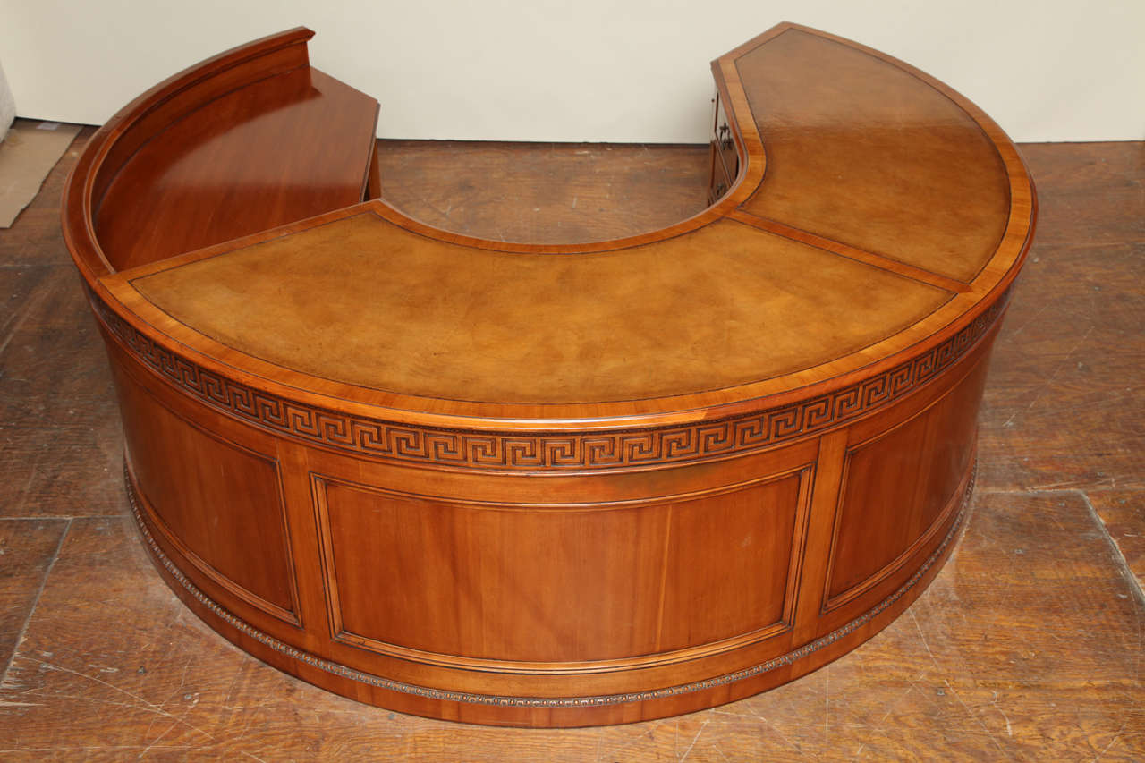 Fine Unique Fruitwood Horseshoe Shaped Desk with Three Panel Blind Tooled Leather Top. Front with Hand Carved Egg & Dart Detail above Greek Key Frieze, Recessed Panels and Egg & Dart Carving above Plinth Base.  One Central Pencil Drawer and Two Box