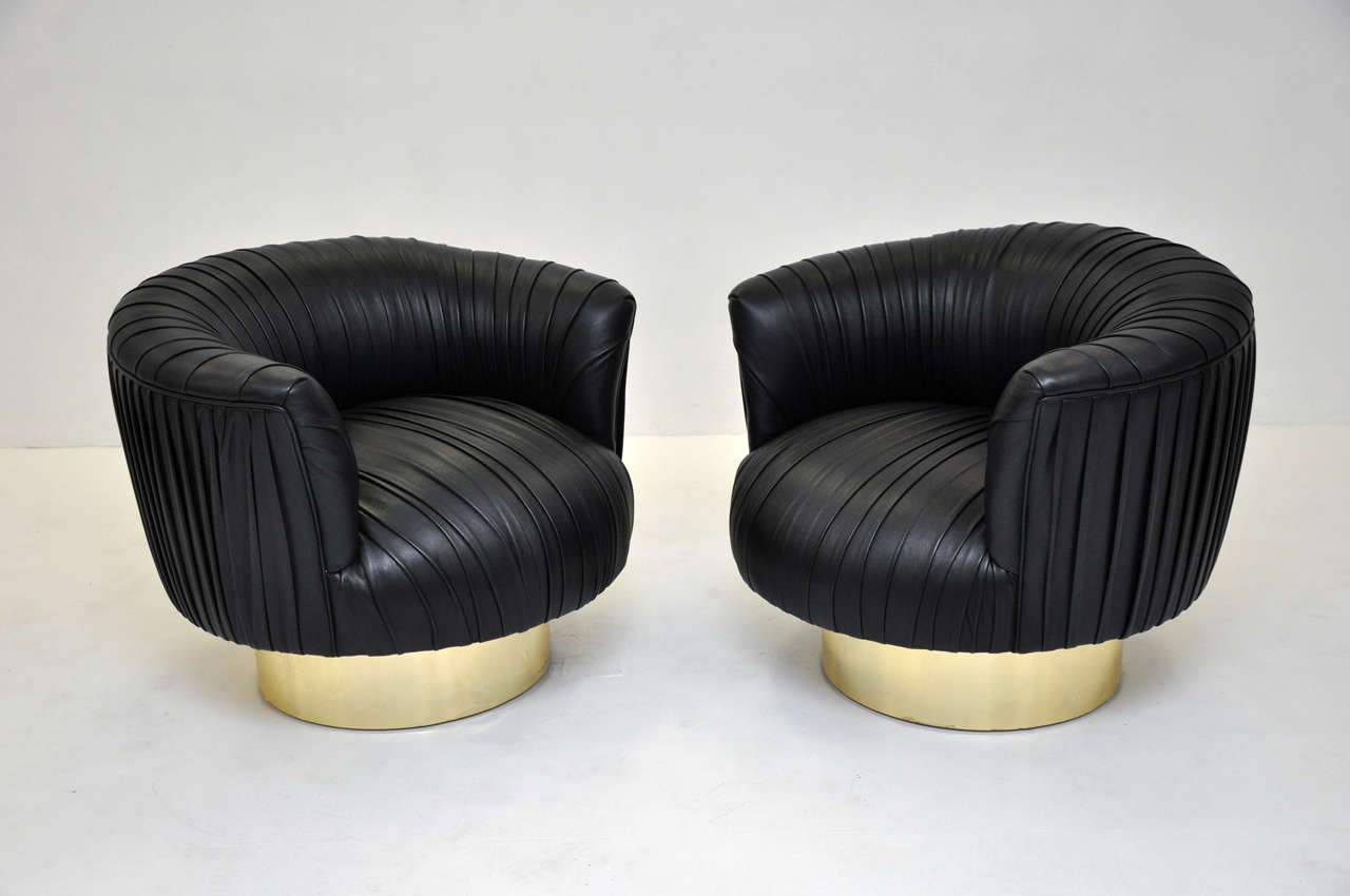 Swivel lounge chairs on brass bases attributed to Milo Baughman.  Reupholstered in black leather using original ruched pattern.