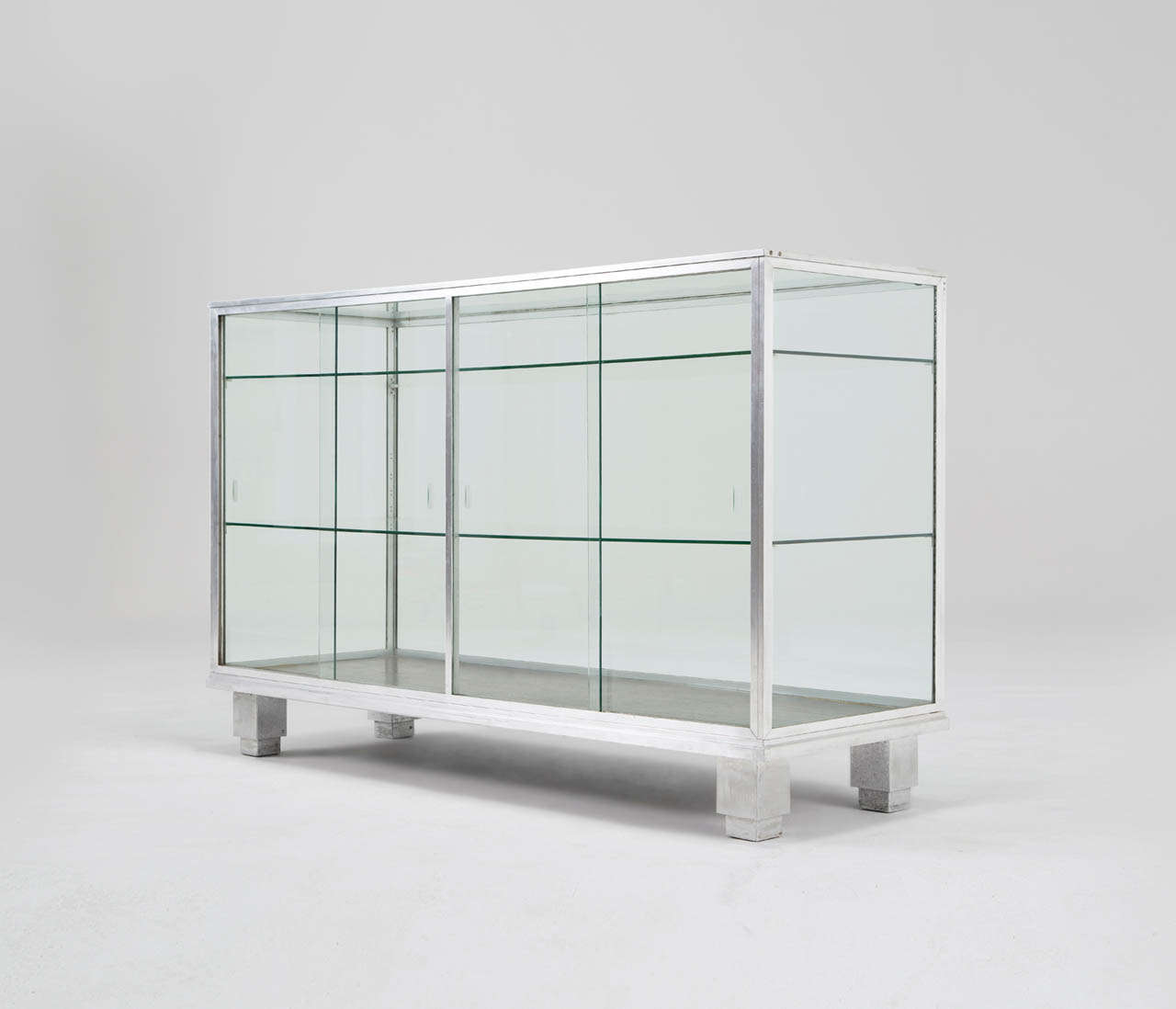 Vitrine, aluminum, glass, France, 1940s.

Equipped with cubistic shaped legs, sliding doors and several glass shelves.
Nice patina to the aluminum, can be completely polished if preferred.

Free shipping for all European destinations and discounted