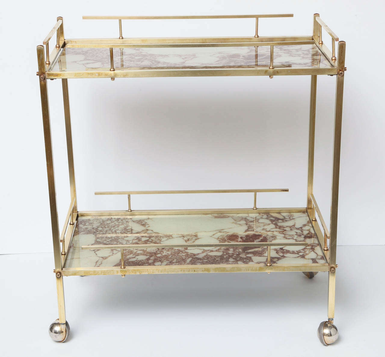 Decorative brass bar cart, C 1940. Beautiful original brass color. 
The glass tops look like marble.