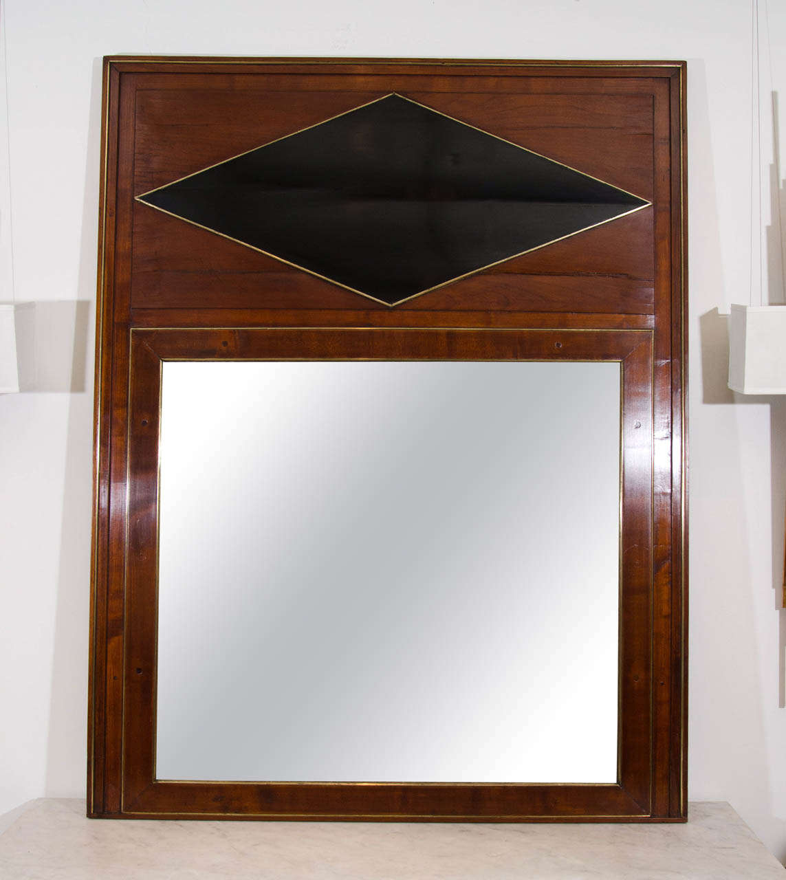 Empire mahogany trumeau mirror with brass trim and ebonized diamond center detail.