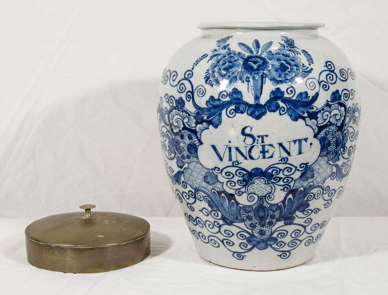 An early 19th century Dutch Delft Blue and White tobacco jar with cobalt decoration of flowers and scrolling vines encircling 