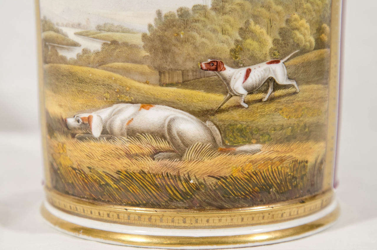 A large outstanding porter (beer) mug with a well painted scene of hunting dogs at work. The scene shows a pair of hounds in fields, rolling hills, and in the background a winding river. One hound points. The other dog low to the ground is still and