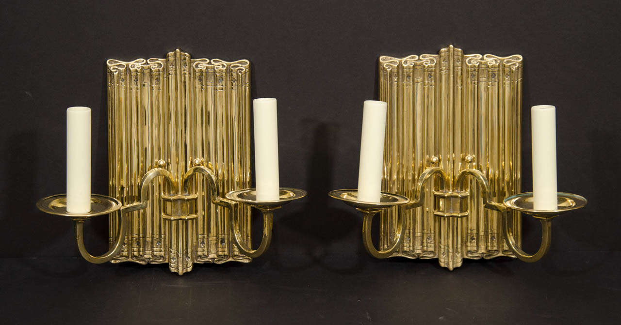 Pair of polished brass two light linen fold motif sconces.