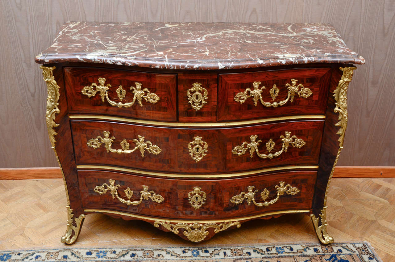 Surmounted by a moulded marble top, containing two short and two long drawers with veneered panels applied with foliate handles and mask key
the short cabriolet legs with pierced sabots.
Stamped FL unknown but listed in cabinetmakers of the 18th