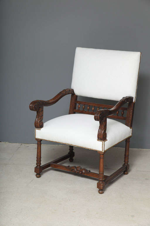 Gorgeous hand-carved Louis XII armchairs. The details in the carvings and back spindles separate these chairs from others like them.  Bottom stretchers across legs. Fully restored and upholstered in a thick Belgian Linen with french brass tacks