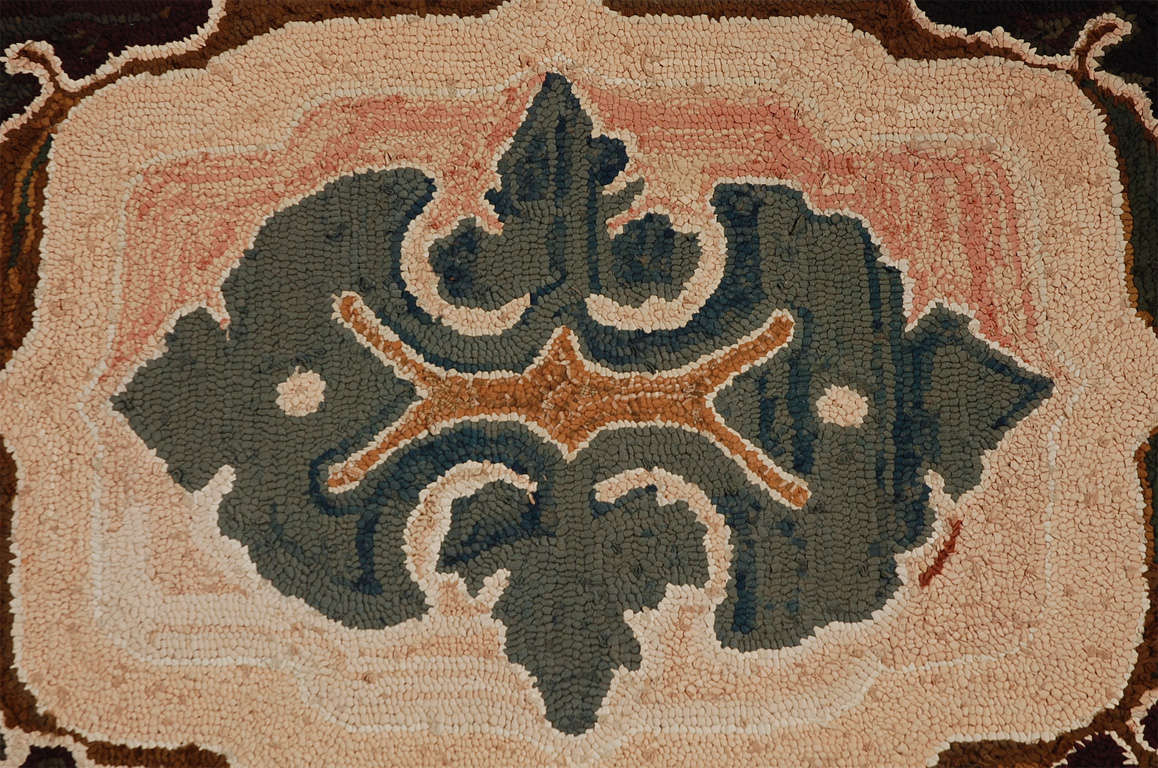 Wonderful salmons and multicolored shades in this geometric hand-hooked rug from Lancaster County, Pennsylvania .This wonderful multiple saw-tooth borders rug with an outlined border. This mounted hand-hooked rug is in pristine condition. Ready for