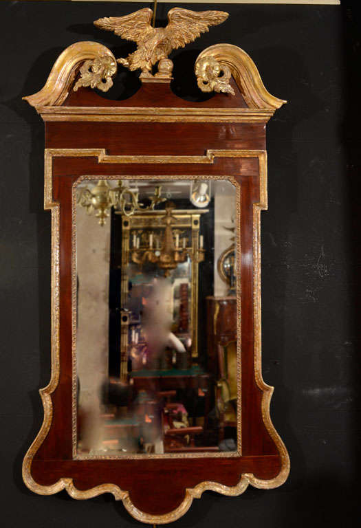 A fine George II mahogany and gilt scroll top mirror with carved eagle and acanthus leaves.