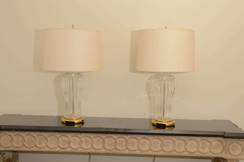 This elegant pair of large glass ribbed lamps which are mounted on polished brass and have been newly rewired with brass double clusters and are accompanied with new ivory paper shades.