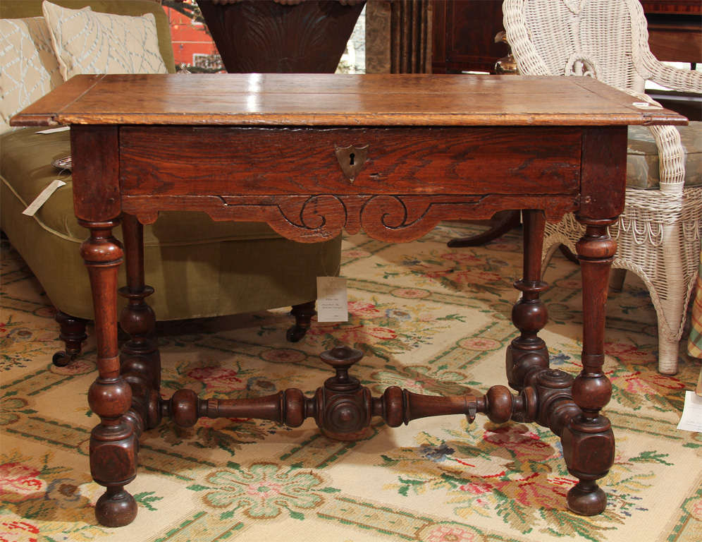Carolean walnut carved side table with one single drawer, and carved apron underneath. Rectangular top raised on turned legs and stretchers. This decorative style was popular in England between 1660 and 1689 during the reign of Charles II. It is