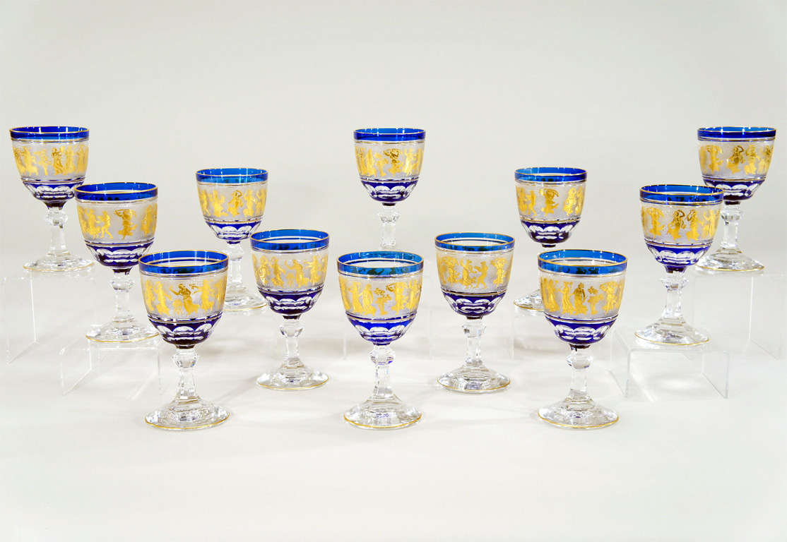 A magnificent set of 12 goblets made by Val St. Lambert. Each one is hand blown with cobalt crystal overlay, cut to clear with cameo cut frieze of Roman figures embellished with gold leaf. This pattern is one of Val St. Lambert's finest and creates