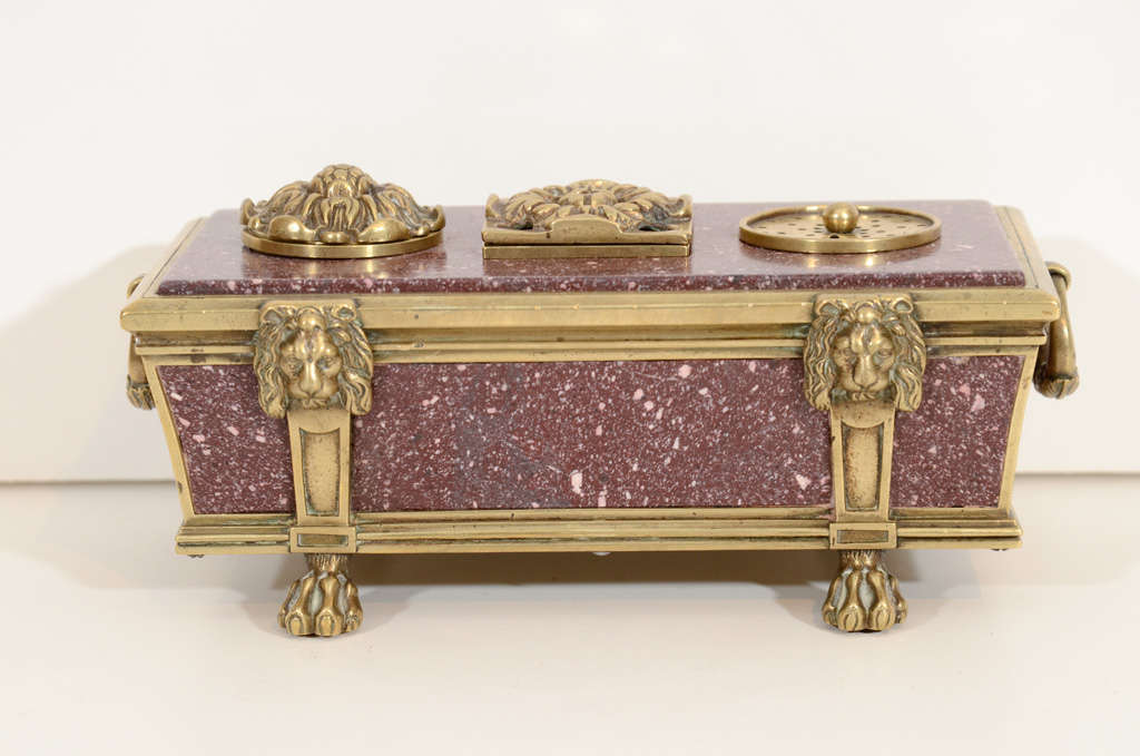 A rare English Regency sarcophagus form
bronze-mounted porphyry inkwell,
circa 1810.