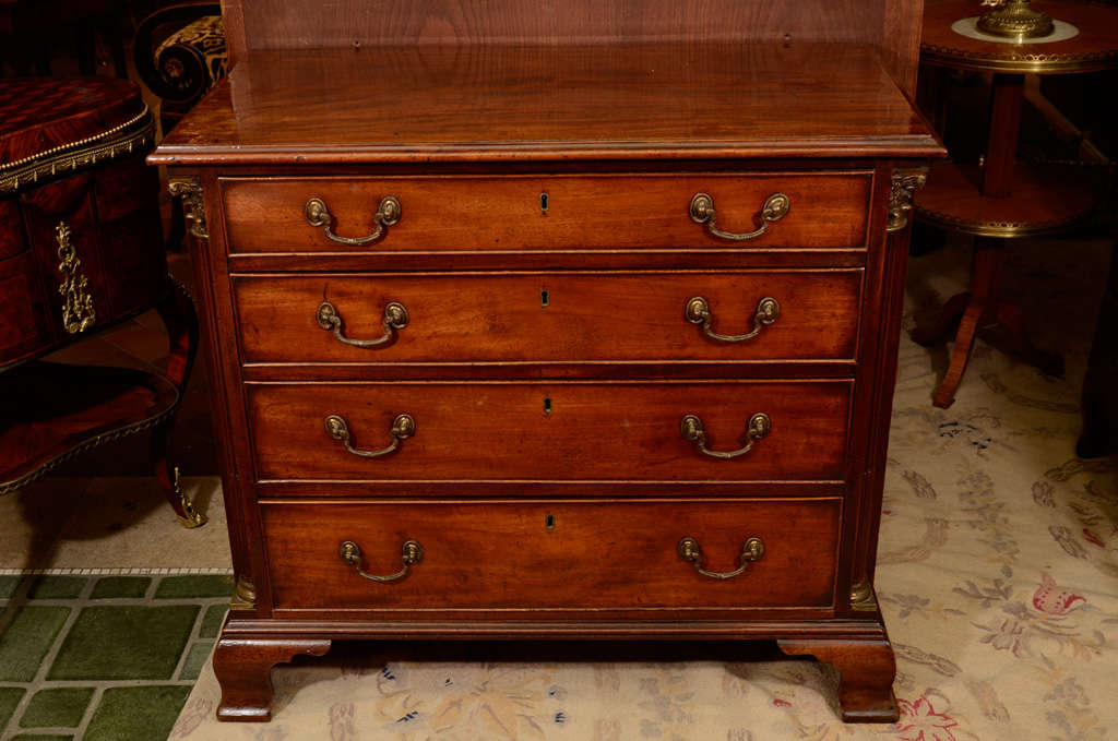 A fine George II mahogany Chippendale chest of drawers with stop fluted corner columns and ogee bracket feet.